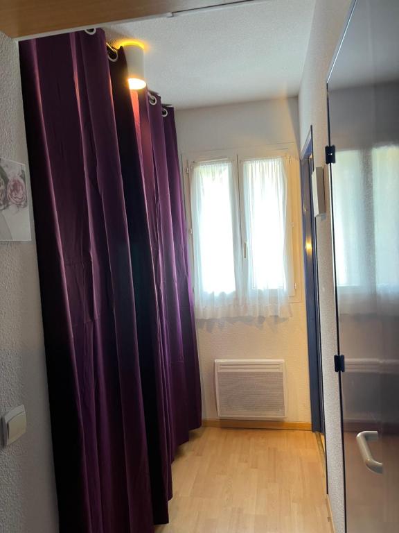 a hallway with purple curtains and a window at JV APPART** 5 Pers 5mn Luz 15 mn Ardiden in Luz-Saint-Sauveur