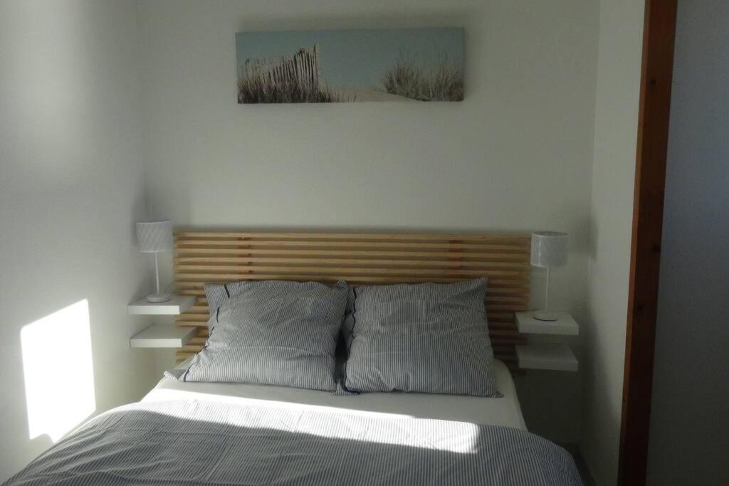 uma cama com uma cabeceira em madeira num quarto em Hossegor Appartement T2 cabine - Superbe Vue Océan em Soorts-Hossegor