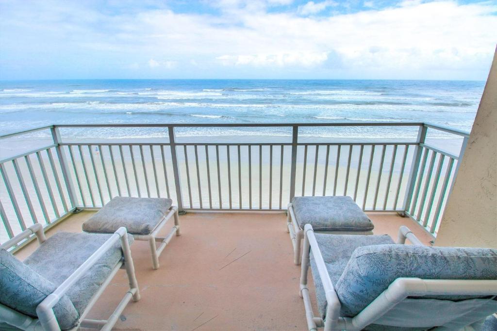 a balcony with chairs and a view of the ocean at Sea Coast Gardens II 401 in New Smyrna Beach
