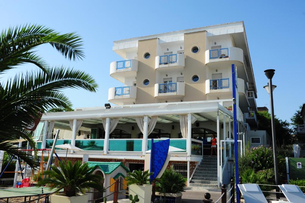 un edificio con piscina y palmeras en Hotel Vienna, en Cattolica