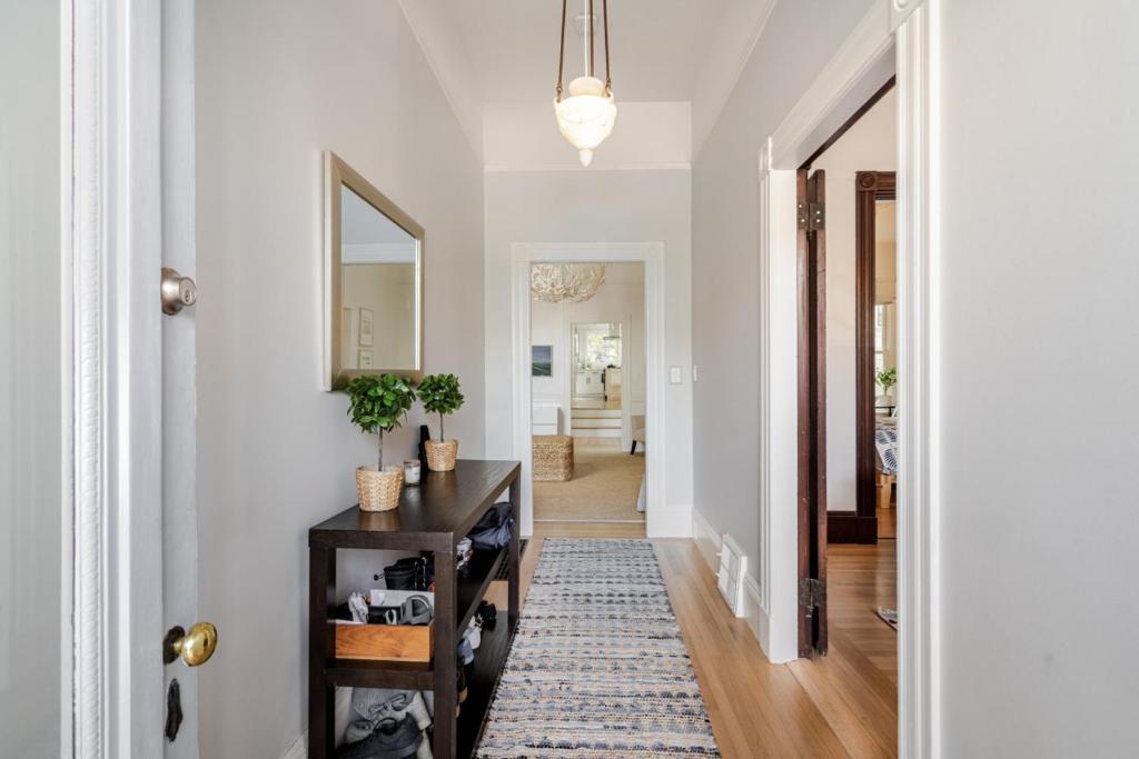 a hallway with a table and a mirror at STYLISH AND SPACIOUS 2ND Flr 2 BR VICTORIAN HOME in San Francisco