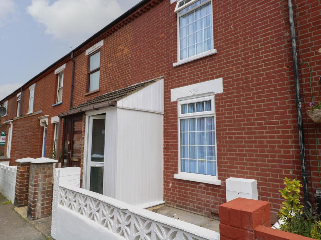 a red brick building with a white garage at Walpole House in Great Yarmouth