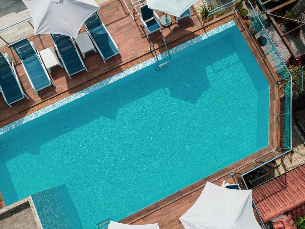 an overhead view of a swimming pool with chairs and umbrellas at Apartments Horizont in Budva
