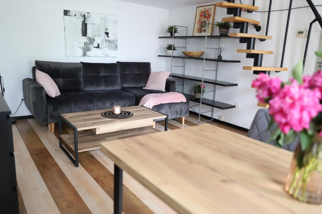 a living room with a black couch and a table at Apartament na Placu Wolnica centrum Kazimierza in Krakow