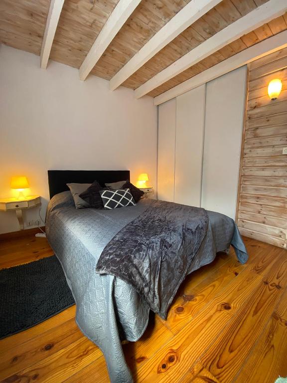 - une chambre avec un lit dans un dortoir doté de parquet dans l'établissement La maison de Mamie, à Pessac
