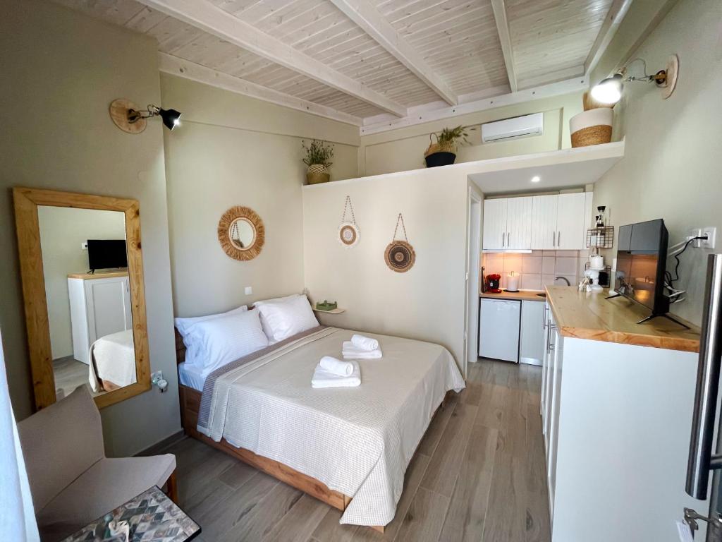 a small bedroom with a bed and a kitchen at Gardy rooms in Nea Kallikrateia