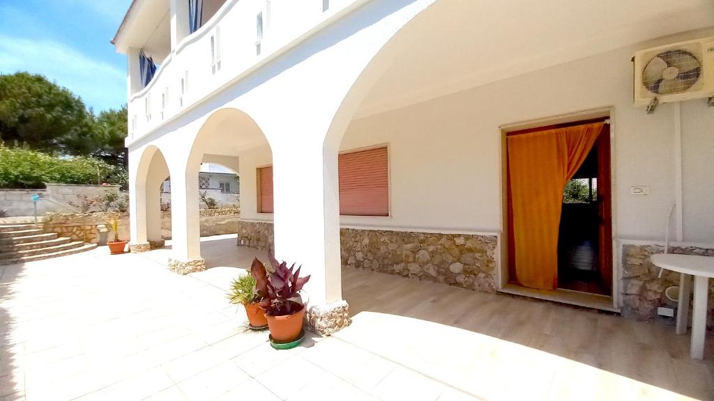 duży biały budynek z drzwiami i patio w obiekcie Villa Montedarena w mieście Pulsano