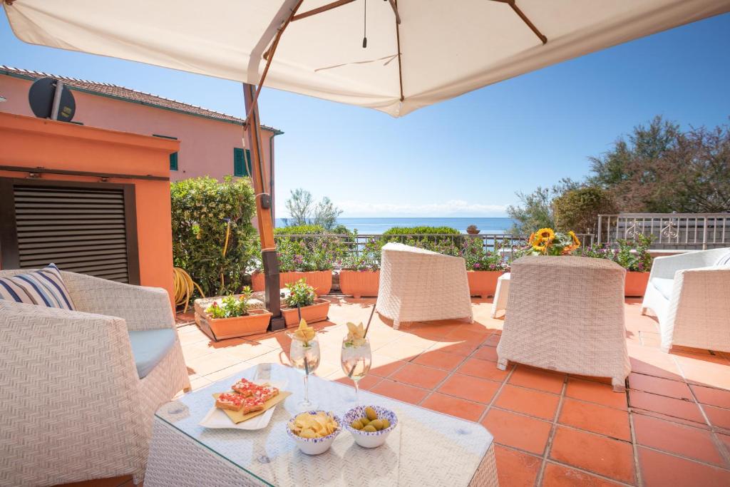 eine Terrasse mit einem Tisch, Stühlen und einem Sonnenschirm in der Unterkunft Hotel Sardi in Pomonte