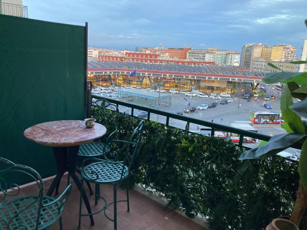 einen Balkon mit einem Tisch und Stühlen sowie Blick auf ein Stadion in der Unterkunft International Garibaldi in Neapel