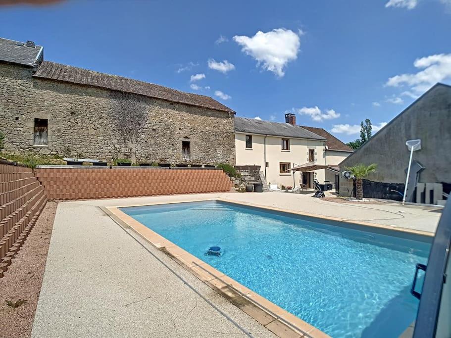 a large swimming pool in front of a building at Le Domaine de la Forge - 12 personnes in Saint-Yrieix-les-Bois