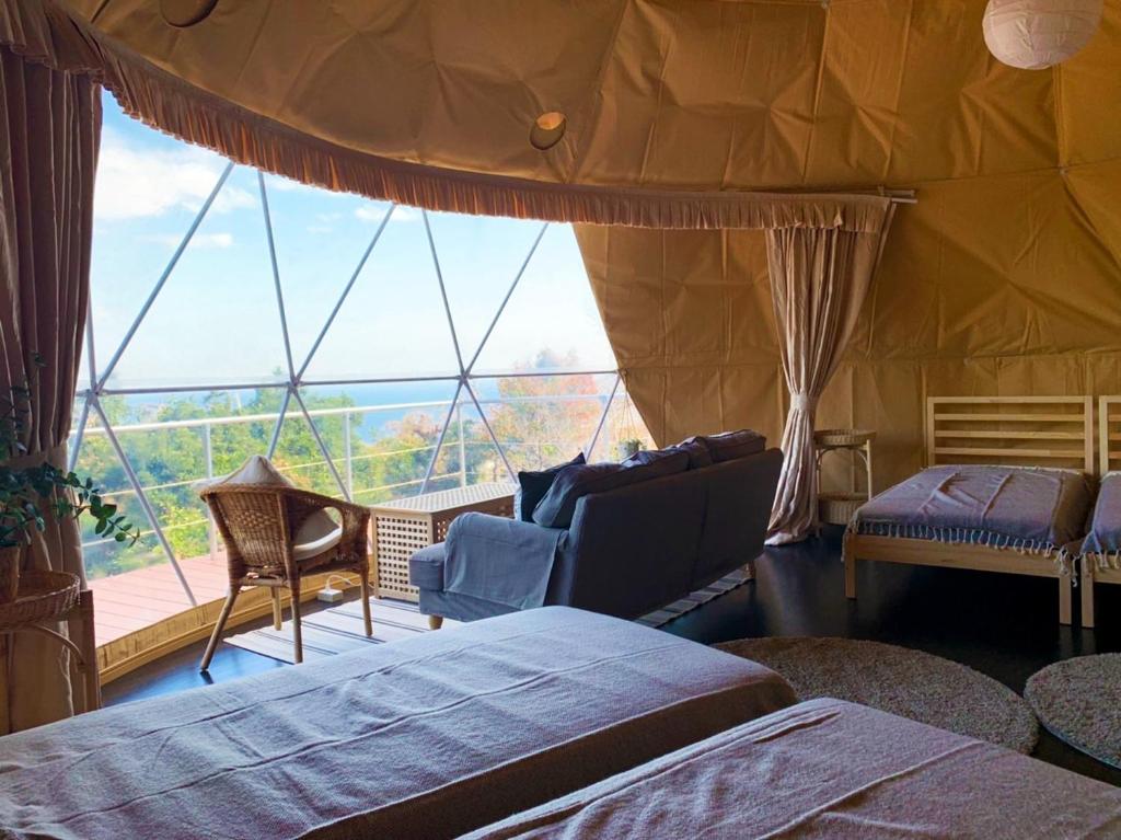 伊東市にあるIzu coco dome tent C - Vacation STAY 87884vのベッド2台と大きな窓が備わる客室です。
