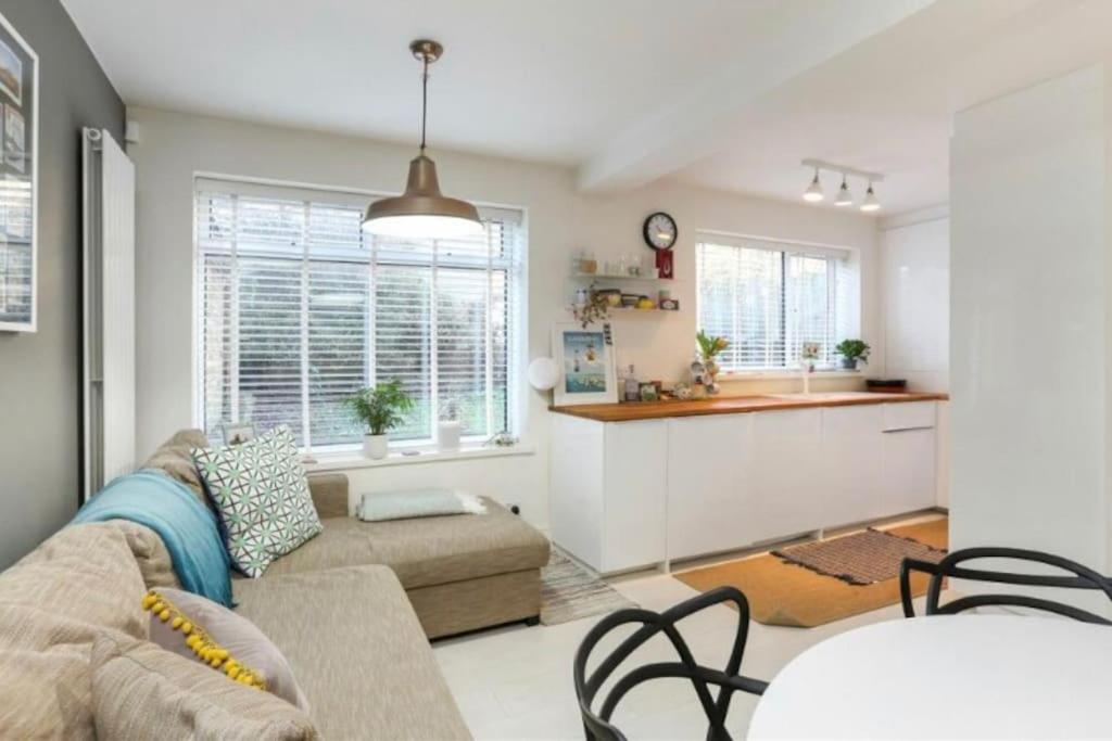 a living room with a couch and a kitchen at Chetwynd Paradise in London