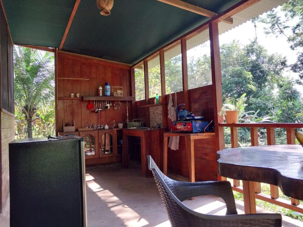 eine Küche mit einem Tisch und Stühlen in einem Haus in der Unterkunft JARDIN DE LAS MUSAS in Puerto Maldonado