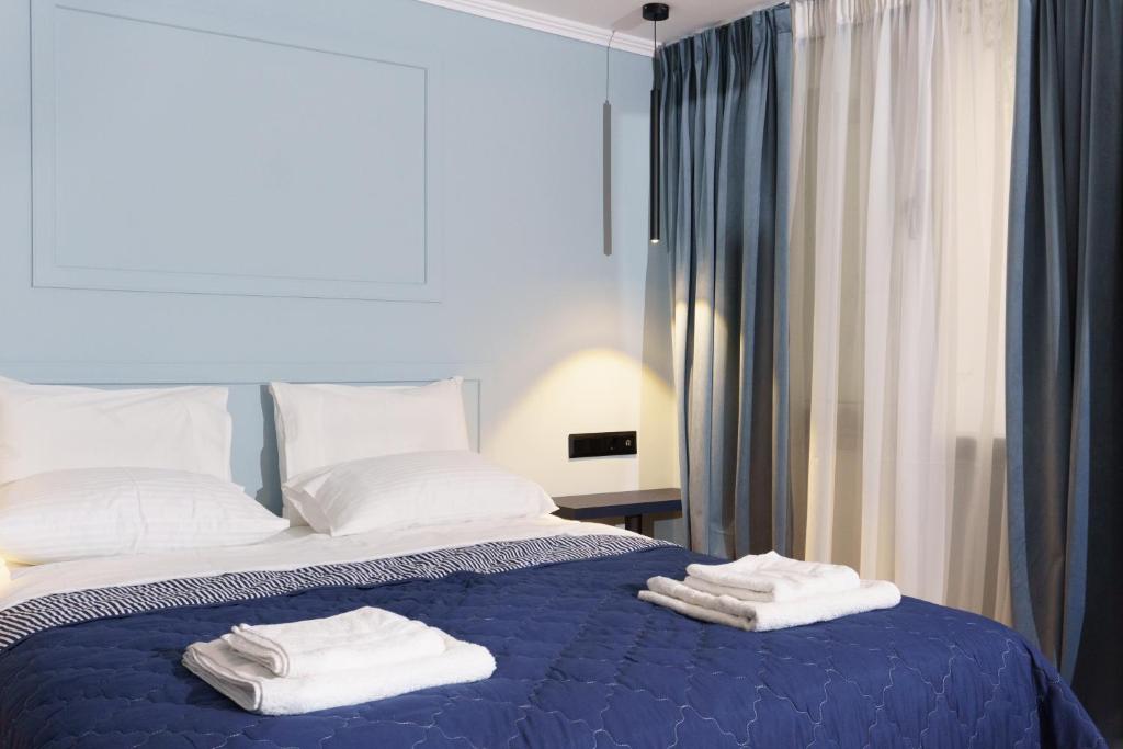 a bedroom with a blue bed with towels on it at Sani Deluxe Suites - Monastiraki Square - Brand New in Athens