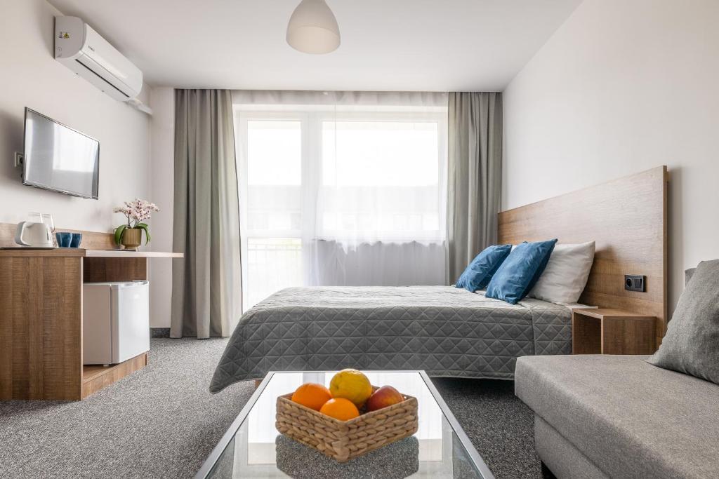 a hotel room with a bed and a bowl of fruit on a table at Dom Gościnny Amare in Pobierowo
