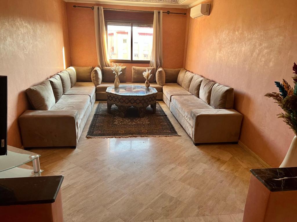 uma sala de estar com um sofá e uma mesa em Appartement les résidences du rêve em Marrakech
