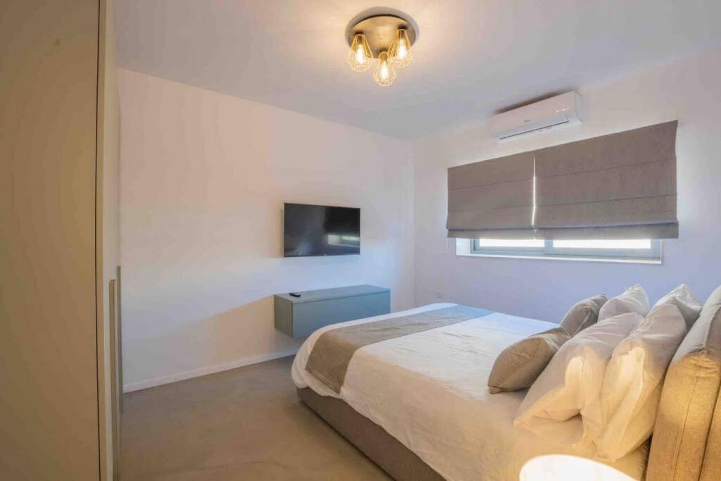 a bedroom with a bed and a window and a television at Wanderlust 2 in Sliema