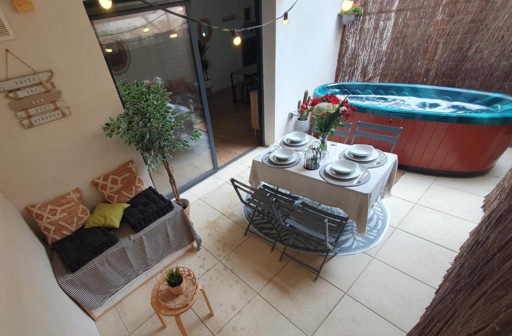 patio con tavolo e vasca idromassaggio di Villa l'Eden de Camargue- Spa et Nature a Candillargues