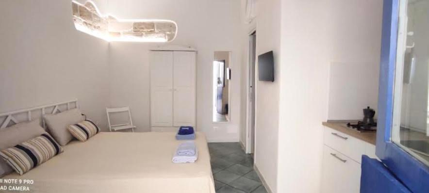 ein weißes Zimmer mit einem großen weißen Bett und Kissen in der Unterkunft Punta San Simone in Marettimo