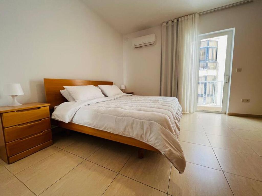 um quarto com uma cama, uma cómoda e uma janela em Tigne 3 Sliema one bedroom apartment em Sliema