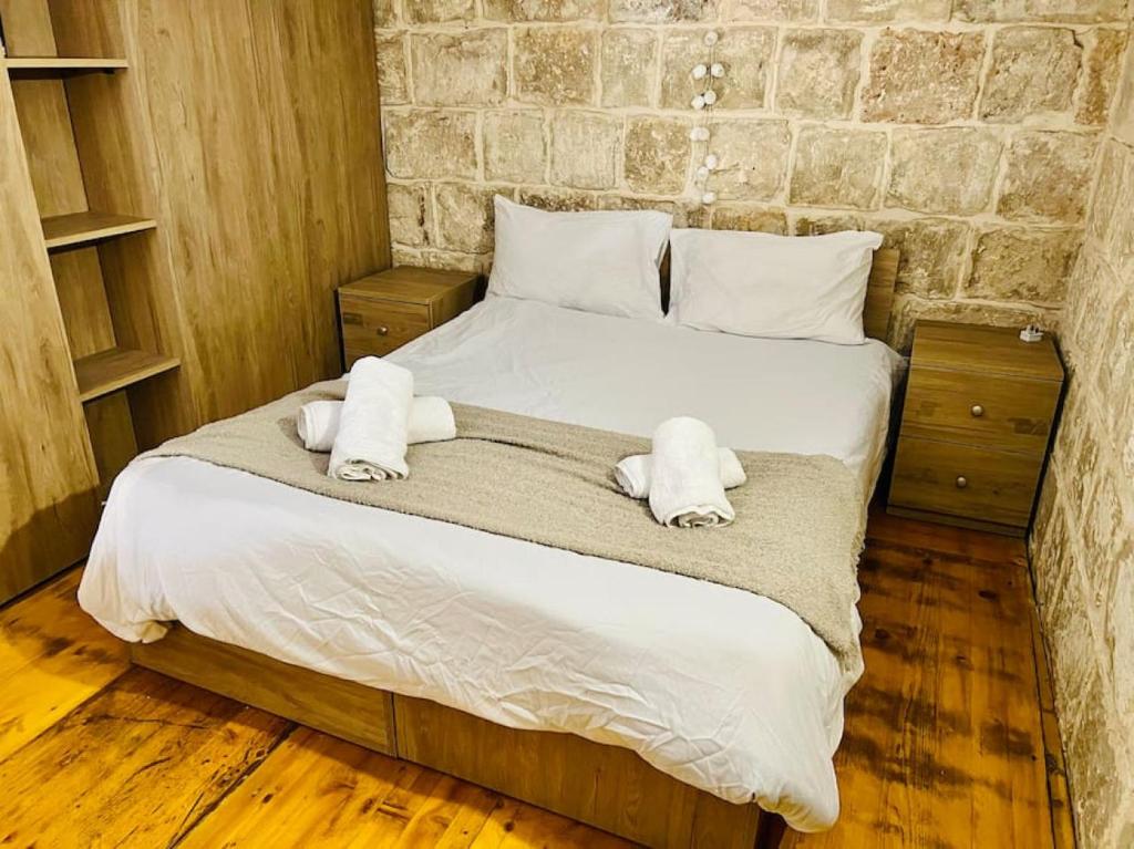 ein Schlafzimmer mit einem Bett mit Handtüchern darauf in der Unterkunft Serenity 2 in Qormi