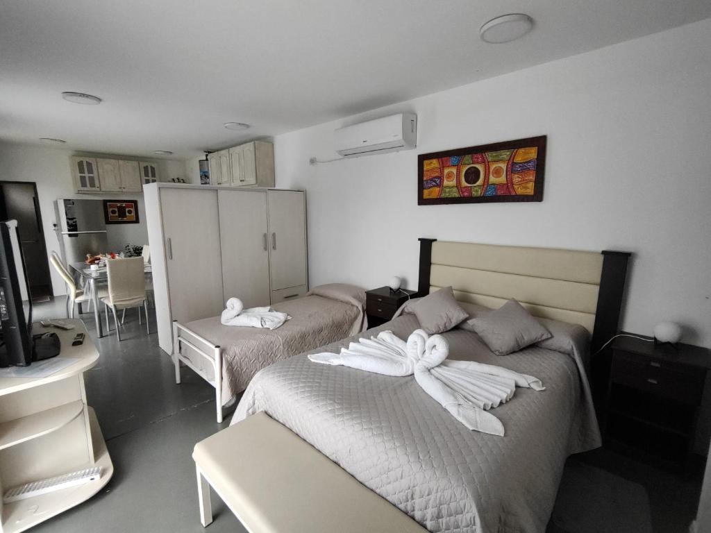 1 dormitorio con 2 camas y toallas. en Terraverde Apartment en Luján de Cuyo