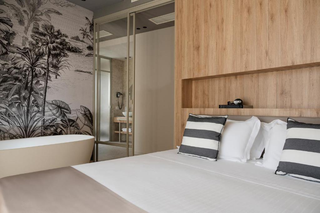 1 dormitorio con 1 cama blanca grande con almohadas blancas y negras en Hotel Luxor, en Milano Marittima