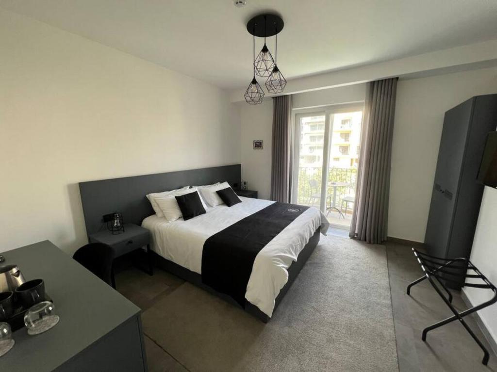 sypialnia z łóżkiem, stołem i oknem w obiekcie The Valley Room 8 condo with parking on premises w mieście St. Julian’s
