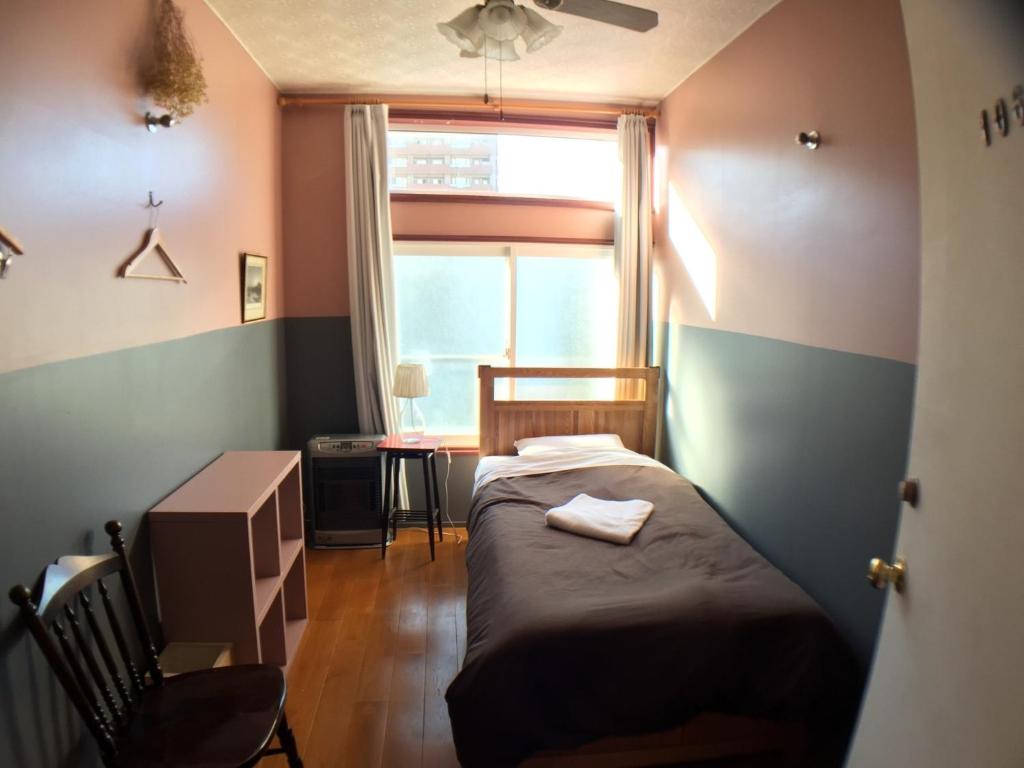 - une petite chambre avec un lit et une fenêtre dans l'établissement Little Barrel - Vacation STAY 57887v, à Otaru