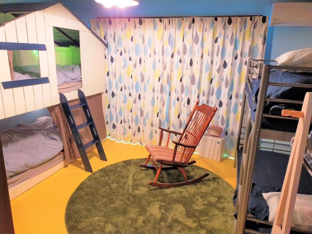 Cette chambre comprend un fauteuil à bascule et des lits superposés. dans l'établissement Soma City - House - Vacation STAY 14688, à Komagamine