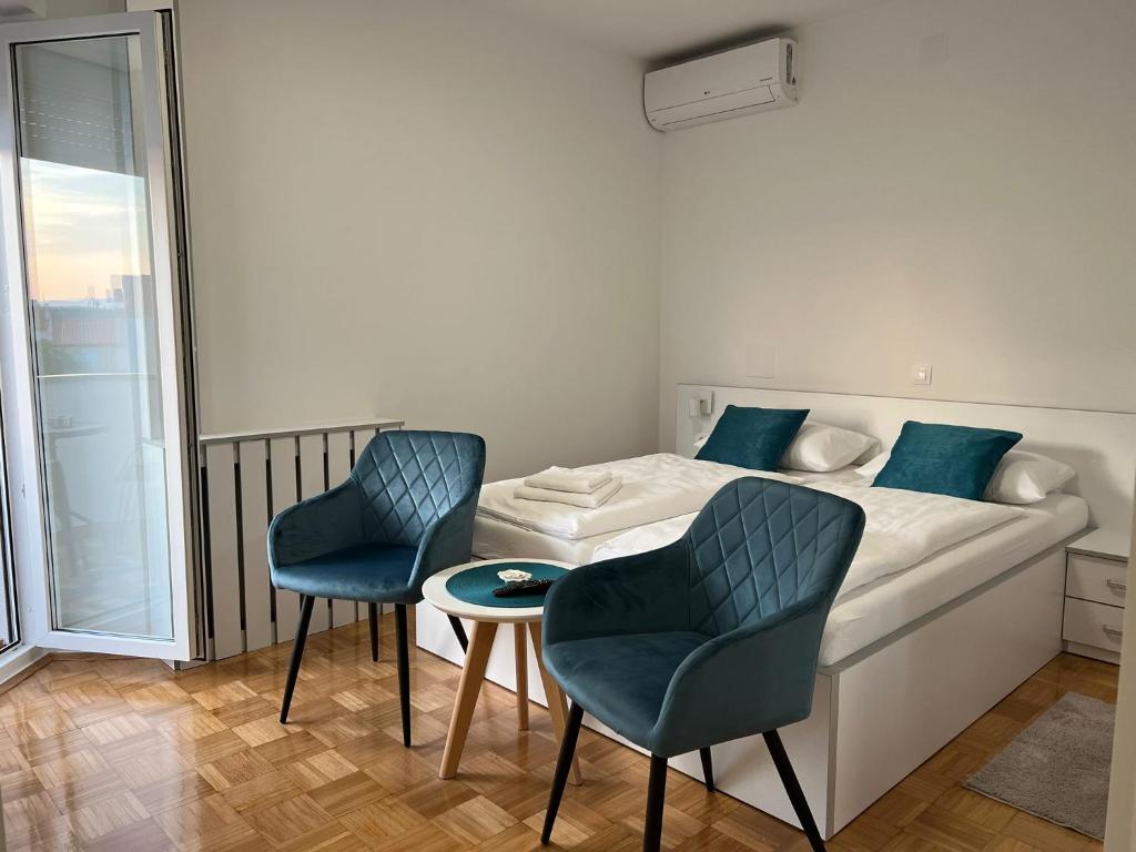 um quarto com uma cama com 2 cadeiras e uma mesa em Villa Rosa Rooms em Punat