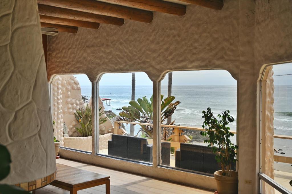 a room with a view of the beach through windows at Balcones Del Mar in Rosarito