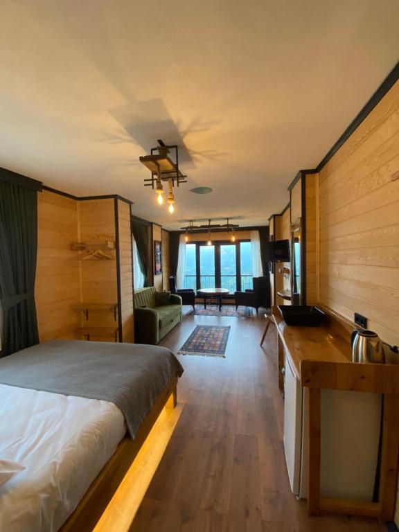 - une chambre avec un lit et un salon dans l'établissement SoOnSuitApart, à Çamlıhemşin