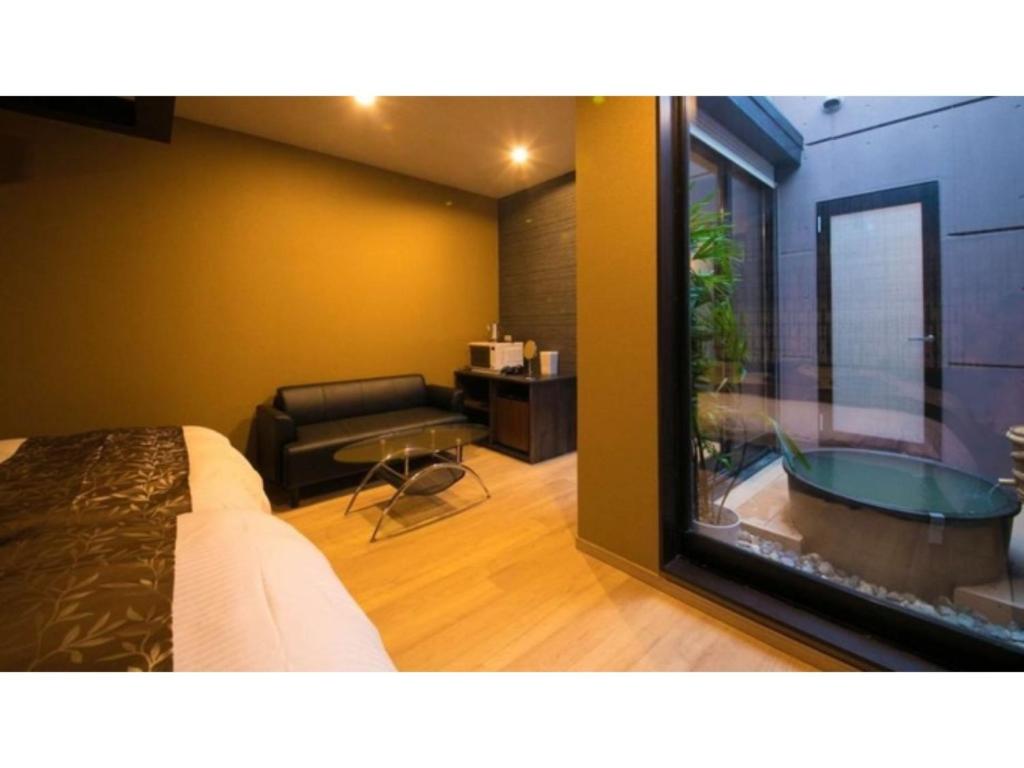 a bedroom with a bed and a tub in a room at Oita Onsen Business Resort Sourin - Vacation STAY 73386v in Oita