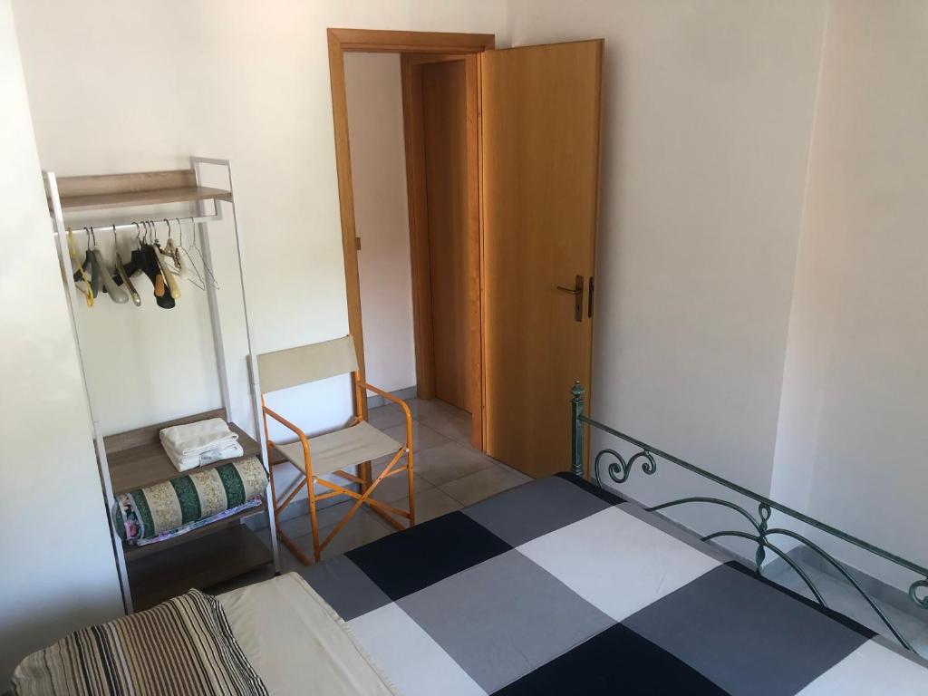 una camera con un letto, una sedia e una porta di Mare Luna Casa a Taormina