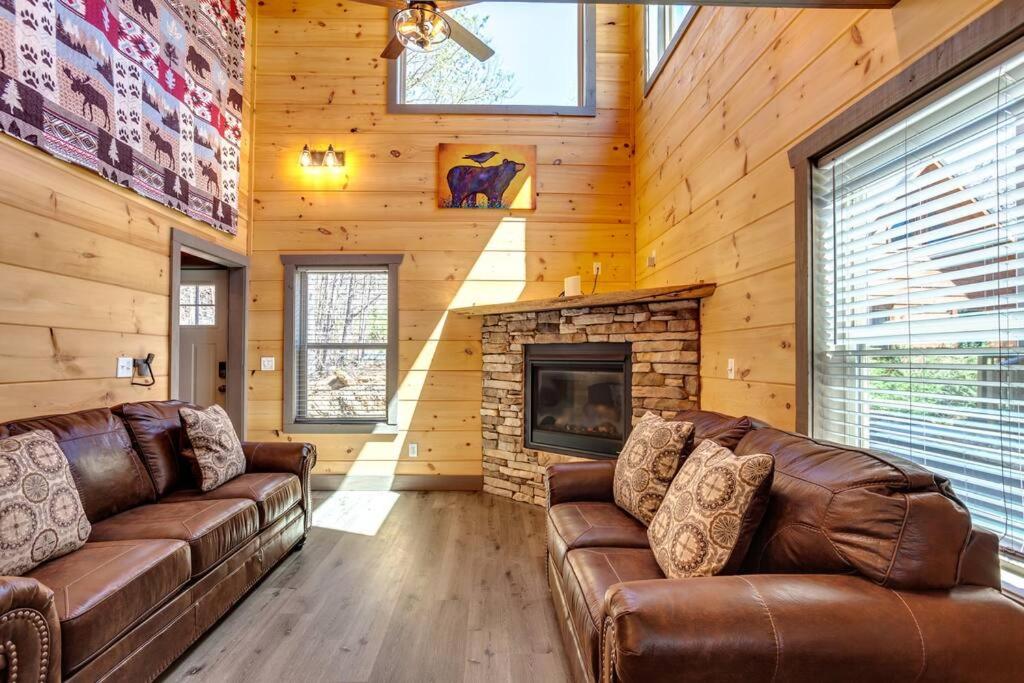 a living room with leather couches and a fireplace at Teddy Bear Cabin in Sevierville