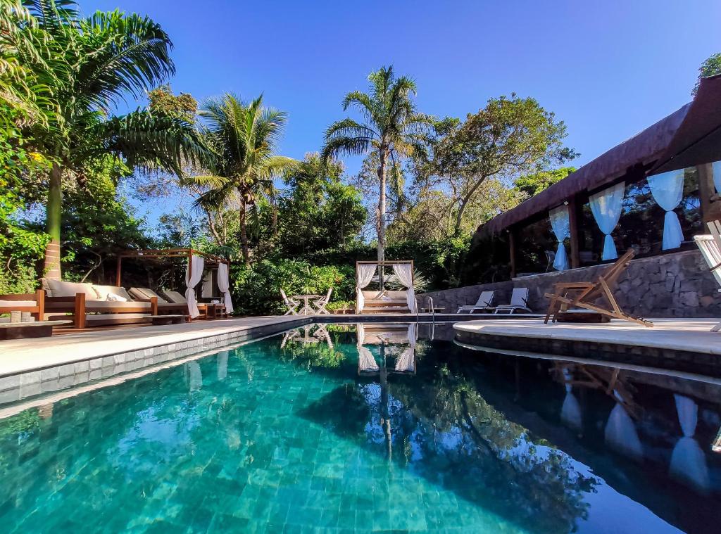 una piscina con sillas y un complejo en Taman Búzios Hotel, en Búzios