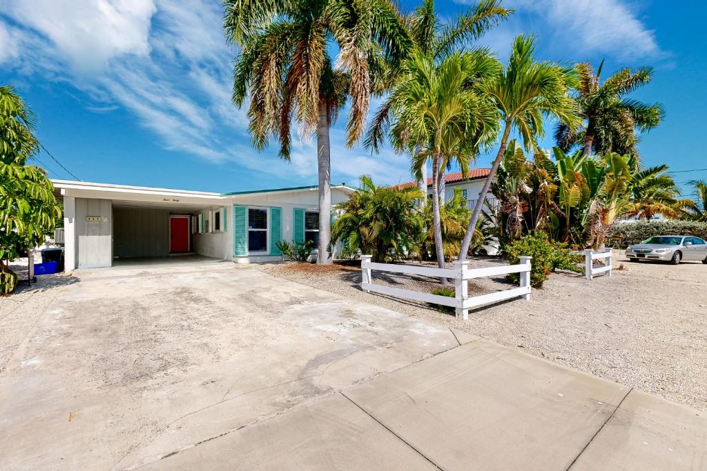 a house with palm trees in front of it at Breezy Keys in Key Colony Beach
