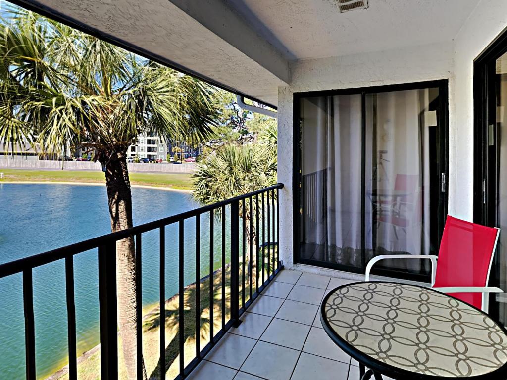 Un balcón con una mesa y una palmera en Edgewater Villa 2112, en Panama City Beach
