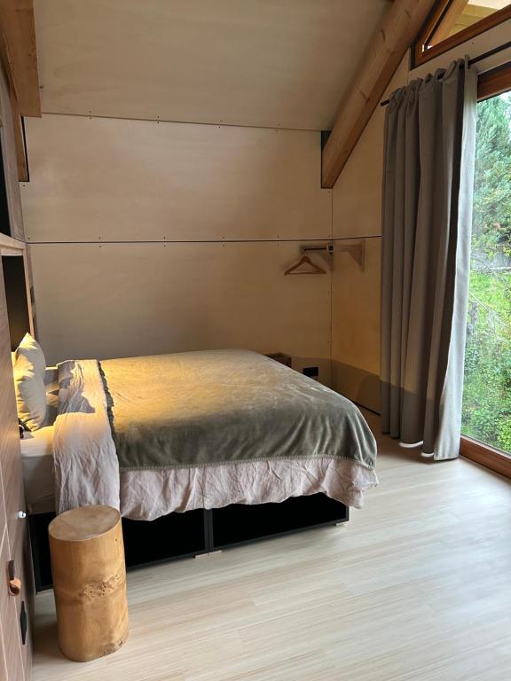 a bedroom with a bed and a large window at Le Cabanon in Saint-Jorioz