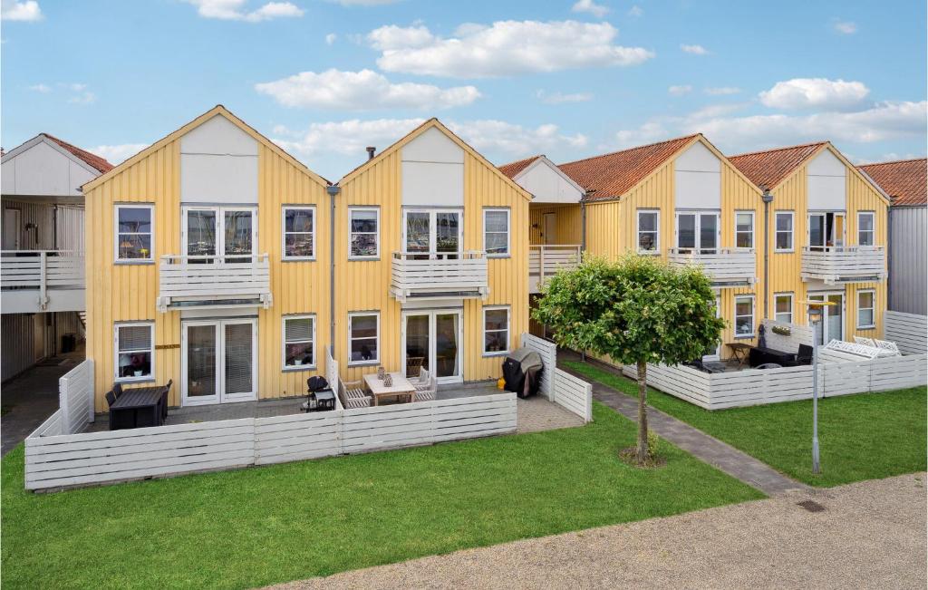 a row of homes with yellow and white at Nice Apartment In Rudkbing With Wifi And 2 Bedrooms in Rudkøbing