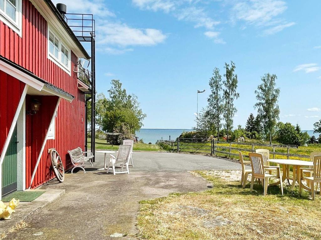 a table and chairs sitting next to a red building at 8 person holiday home in BRÅLANDA-By Traum in Brålanda