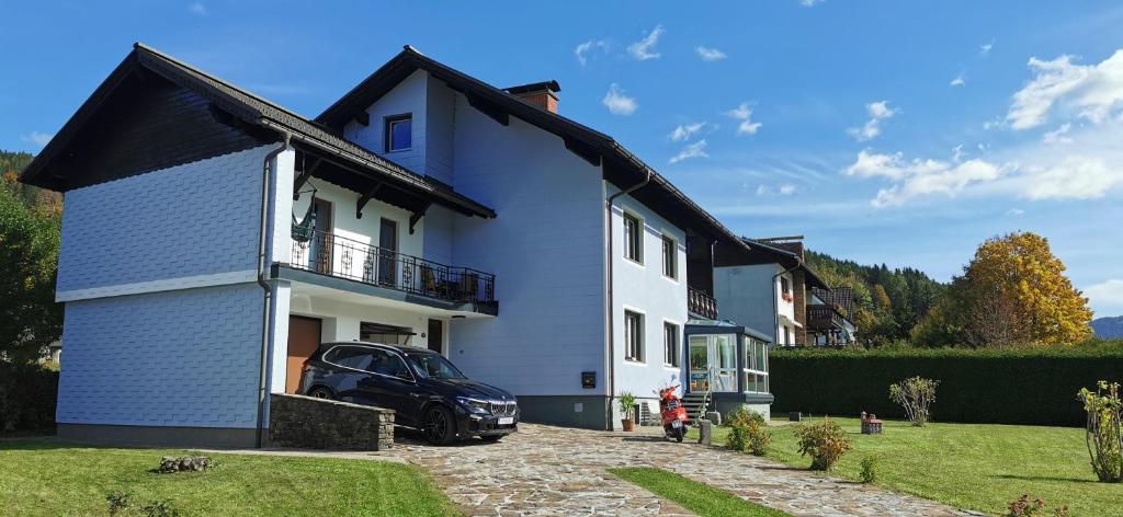 una casa azul con un coche aparcado delante de ella en Haus Alpenland, en Mariazell