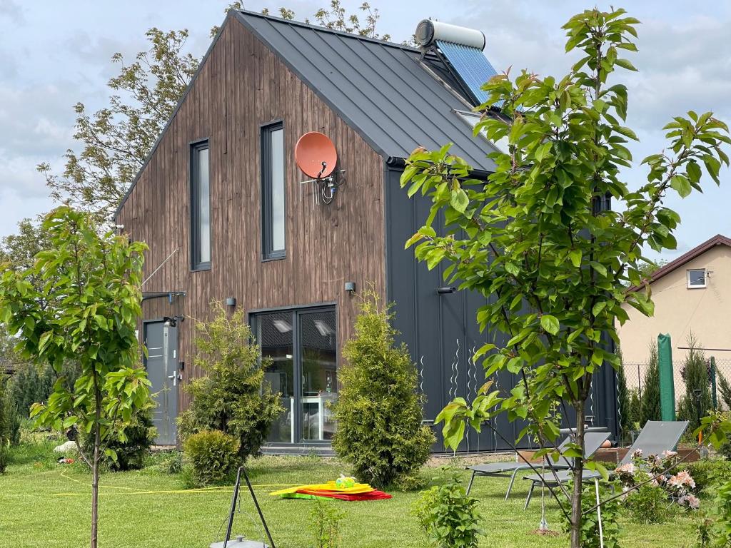 a barn style house with a black roof at Appena Guest House in Krakow
