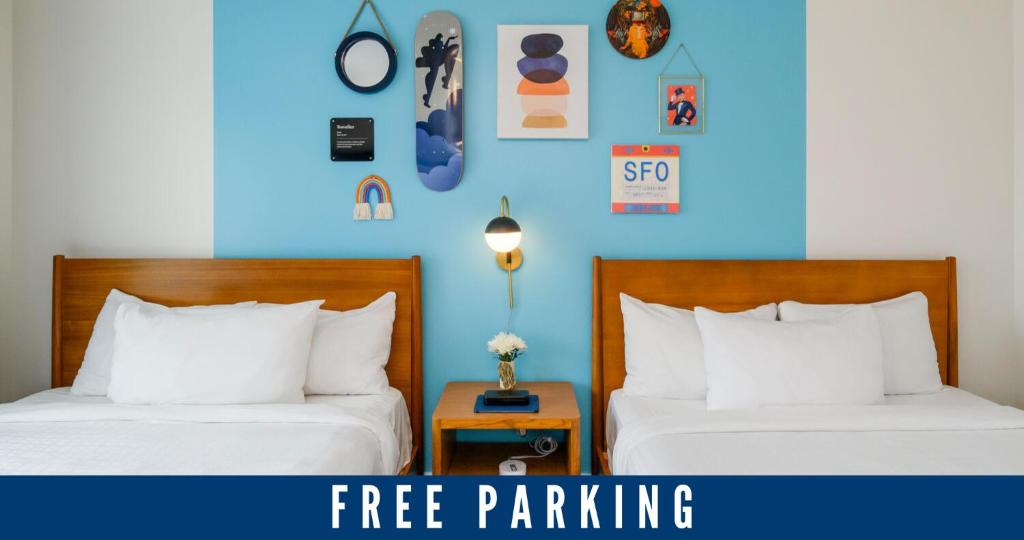 - 2 lits dans une chambre avec un mur bleu dans l'établissement Beck's Motor Lodge, à San Francisco