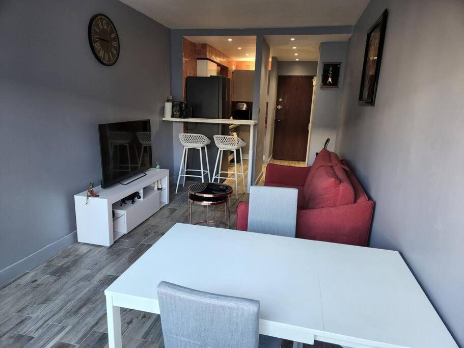 uma sala de estar com uma mesa branca e um sofá em Appartement cosy Puteaux centre em Puteaux