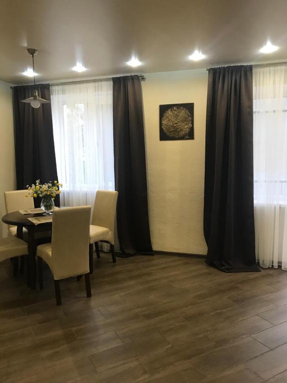 a dining room with a table and chairs and curtains at Квартира подобово, погодинно (Центр) Стрий in Stryi