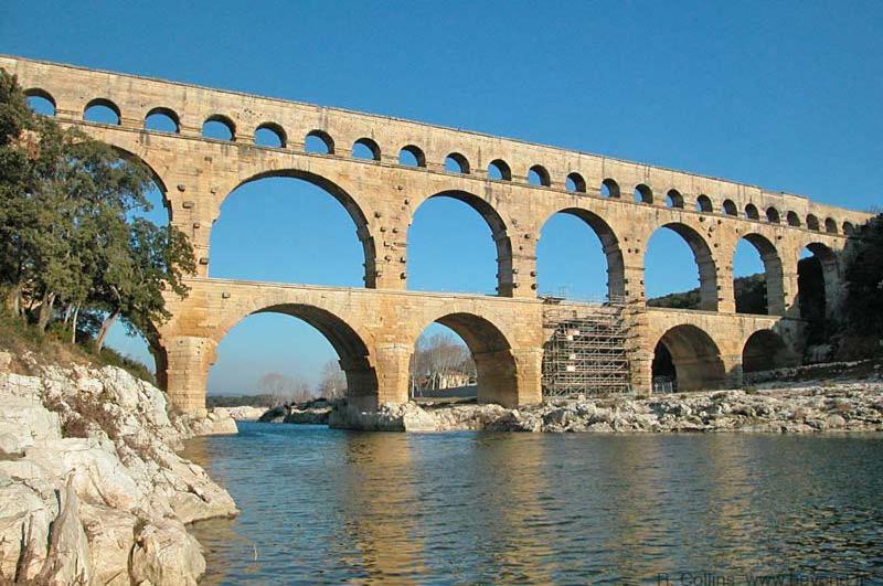 un pont sur une rivière avec de nombreuses arches dans l'établissement Villa pont du Gard 4 Bedrooms, à Remoulins