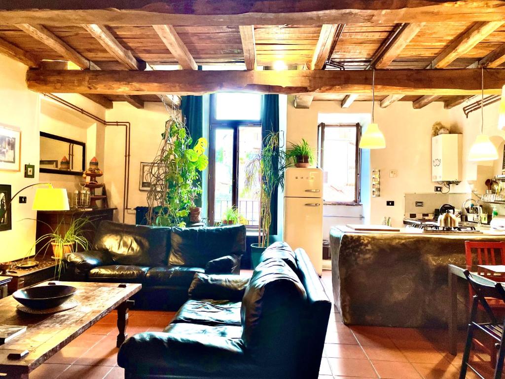 sala de estar con sofás de cuero y cocina en Country Loft in antico monastero, Capena - Roma, en Capena