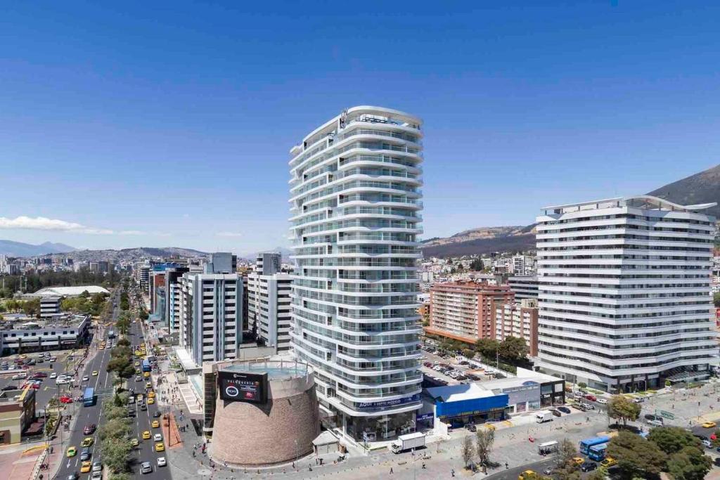 a large tall building in a city with buildings at LovelyView Studio Edif 1 HeatedPool Gym Turco WIFI 1412 in Quito